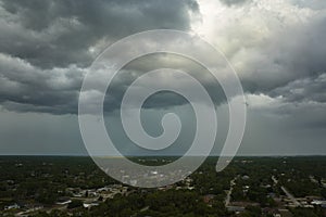 Landscape of dark ominous clouds forming on stormy sky before heavy thunderstorm over rural town area