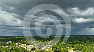 Landscape of dark ominous clouds forming on stormy sky before heavy thunderstorm over rural town area