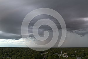 Landscape of dark ominous clouds forming on stormy sky before heavy thunderstorm over rural town area