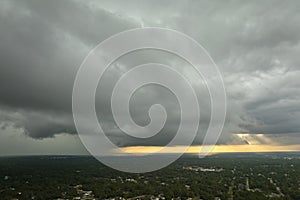 Landscape of dark ominous clouds forming on stormy sky before heavy thunderstorm over rural town area