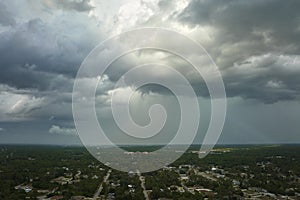 Landscape of dark ominous clouds forming on stormy sky before heavy thunderstorm over rural town area