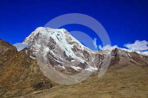 Landscape of deep blue sky and ice capped peaks of himalayan mountains with white clouds during day time