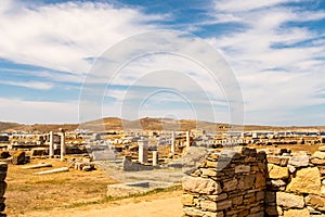 Landscape of Delos Island in Greece - view from the hill on the island with blue cloudy sky and big area of ancient ruins