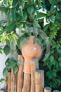 Landscape design clay pitchers pitchers on a woven wooden fence