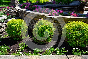 Landscape design of home garden, landscaping with flowers and stone retaining walls
