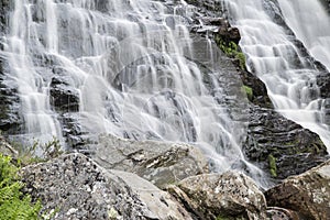 Landscape detail of waterfall over rocks in Summer long exposure