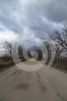 Landscape with a dirt road and cloudy sky