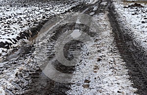 Landscape with dirty road beside an agricultural fiel