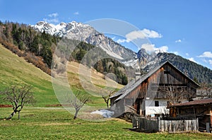 Landscape of Dolomites mountains in summer with a farm and meadows photo