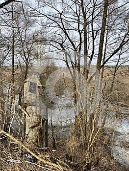 landscape in early in spring - an old abandoned well on the river bank