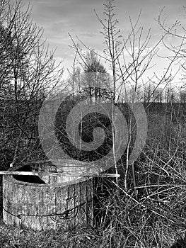 landscape in early in spring - an old abandoned well on the river bank