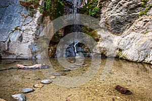 Landscape of Eaton Canyon waterfall in rocky mountains flowing with wild plants, vertical shot