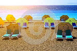 Landscape of Elle beach on Rhodes island. Panorama with sand seacoast with chaise lounges under umbrellas and clear blue water