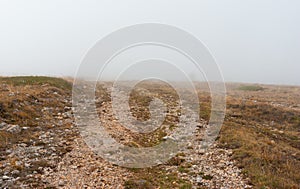 Landscape with empty medieval rocky road in fog on Babuhan Yaila natural reserve
