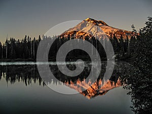 Landscape featuring a majestic Mount Hood reflected in a serene lake during a sunrise