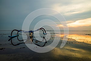 Landscape. Fisherman boat jukung. Traditional fishing boat at the beach during sunrise. Sanur beach, Bali, Indonesia