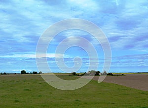 Landscape of flatland, farmstead and meadow. blue sky.