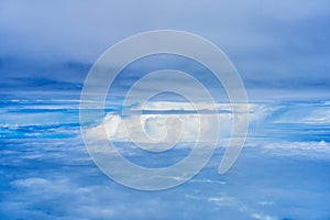 Landscape of fluffy white clouds on a dark blue sky. View from the plane at high altitude