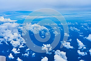 Landscape of fluffy white clouds on a dark blue sky. View from the plane at high altitude