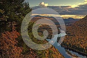 Landscape of forest, hills and river at sunset