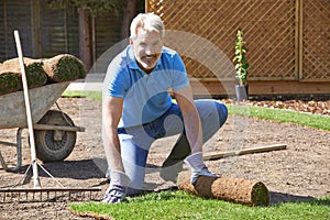 Landscape Gardener Laying Turf For New Lawn