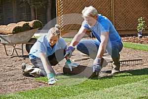 Landscape Gardeners Laying Turf For New Lawn