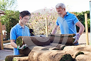 Landscape Gardeners Laying Turf For New Lawn