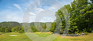 Landscape on a golf course with green grass, trees, beautiful blue sky, panorama