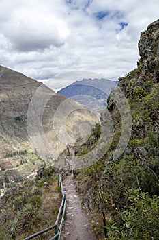 Landscape with green Andean Mountains and Inca ruins on the hiking path in Pisac archeological park, Peru