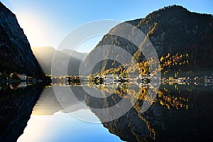 The landscape of Hallstatt, Austria, a riverside village reflecting the calm waters. The shadows in the water look like a mirror