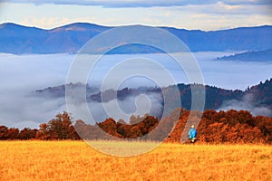 Landscape with high mountains, grey thick fog and sky.