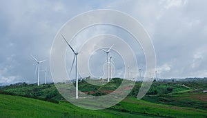 landscape of hills and wind turbines with misty foggy in morning time