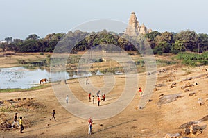 Landscape with Hindu temple of Khajuraho and children playing cricket, India