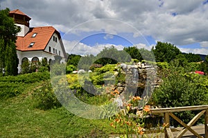 Landscape with house, garden and artificial waterf