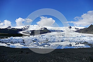 Landscape of icebergs, water and black rock at JÃ¶kulsarlon glacier lagoon, Iceland