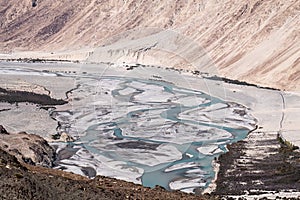 Landscape image of the blue Shyok river on the way to Nubra valley
