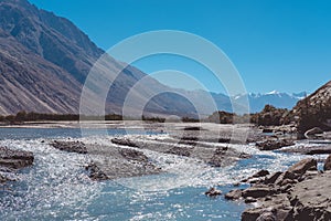 Landscape image of the blue Shyok river on the way to Nubra valley with mountain and blue sky background