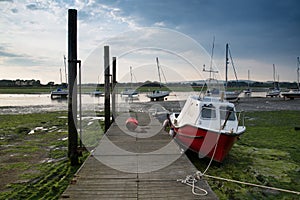 Landscape image of boats mored to jetty in harbor during Summer