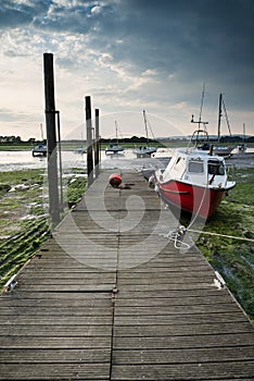 Landscape image of boats mored to jetty in harbor during Summer