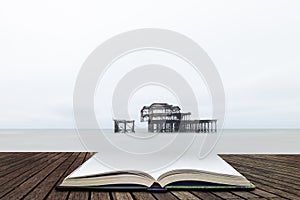 Landscape image of derelict Victorian West Pier at Brighton in West Sussex  in pages of open book, story telling concept