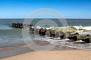 A landscape image of the jetty on the shore in Rehoboth Beach, Delaware on a sunny afternoon.