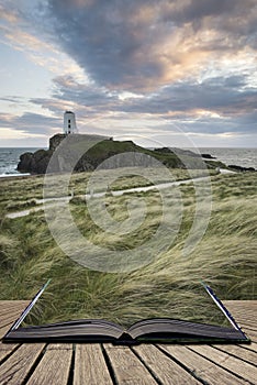 Landscape image of Twr Mawr lighthouse with windy grassy footpath in foreground at sunset concept coming out of pages in book