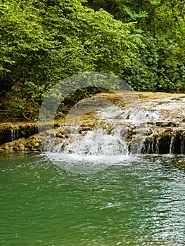 Landscape of incomparable natural beauty with a small waterfall on the Bresque river surrounded by green nature