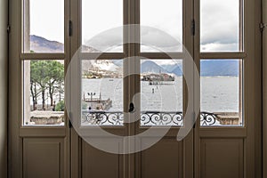 landscape of the islands of Lake Maggiore seen through a glass door of the palace