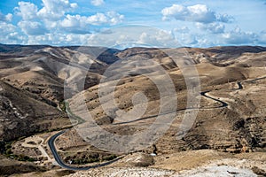 Landscape of Israel desert. Blue Cloudy Sky and road in background. Mountain. Judaean Desert