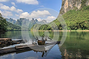 Landscape of karsten mountain in Guilin with a bamboo raft and two comorants