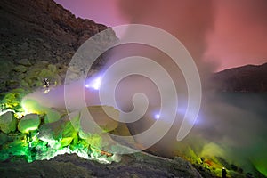 Landscape of Kawah Ijen volcano crater with blue flame and sulfuric smoke view with sunrise dawn morning in East Java, Indonesia