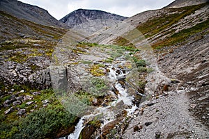 Landscape of the Khibiny mountains with rocks and a mountain stream on a cloudy day. Kola Peninsula, Russia