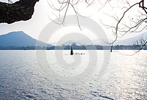 Landscape with the lake, boat, pagoda and mountains.