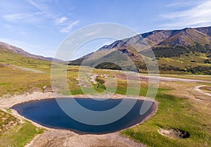 Landscape with a lake in foreground, chooms and mountains